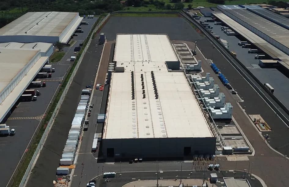 Vista aérea do data center AWS em Paulínia, São Paulo, com cobertura TPO branca de grande porte e equipamentos de climatização industrial no telhado.